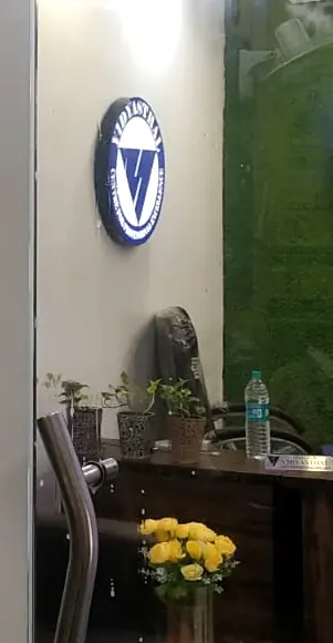 The front desk at Vidyasthal with the round seal mounted on the wall above it